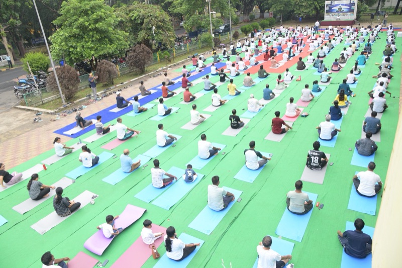 Hundreds of participants seated on yoga mats across a green ground at IIT Kharagpur